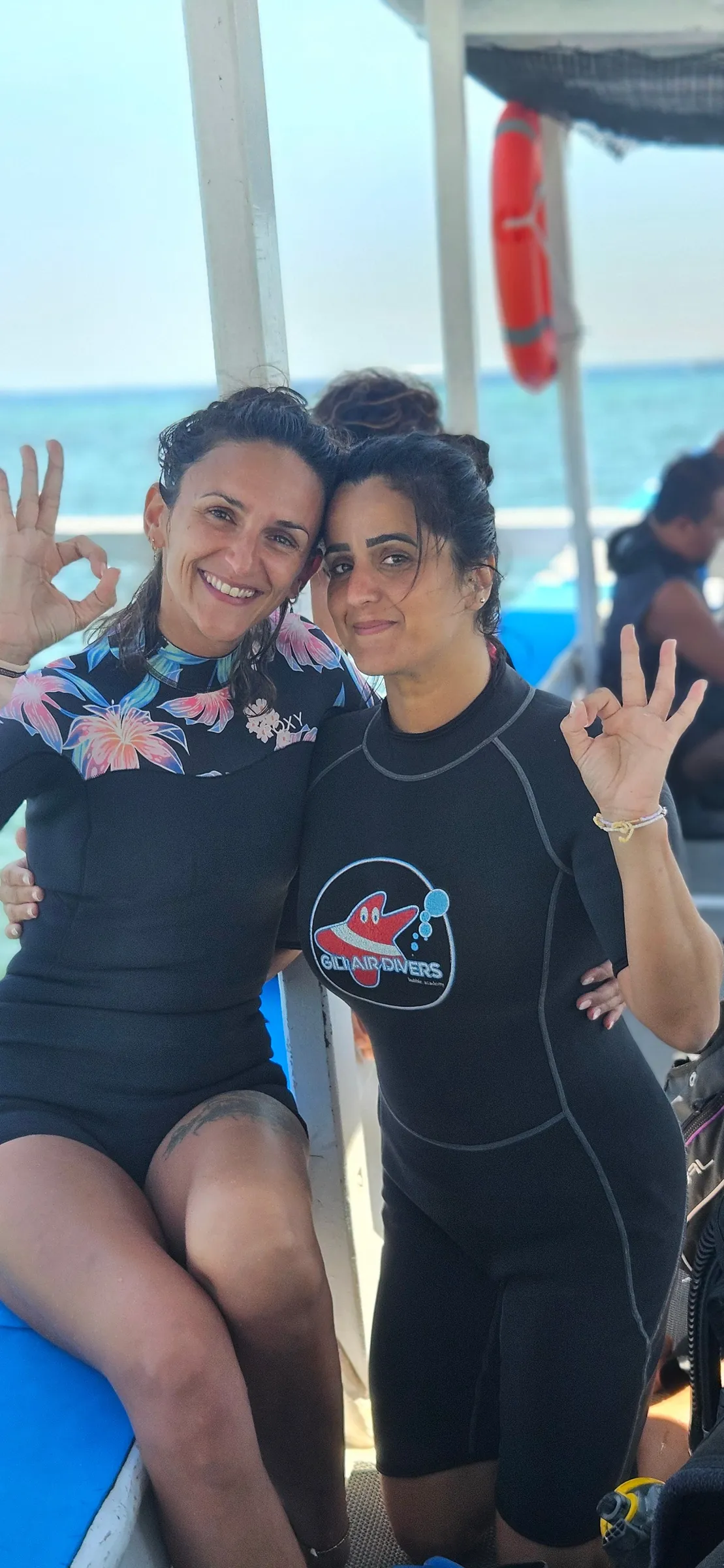 Two divers signaling OK on boat