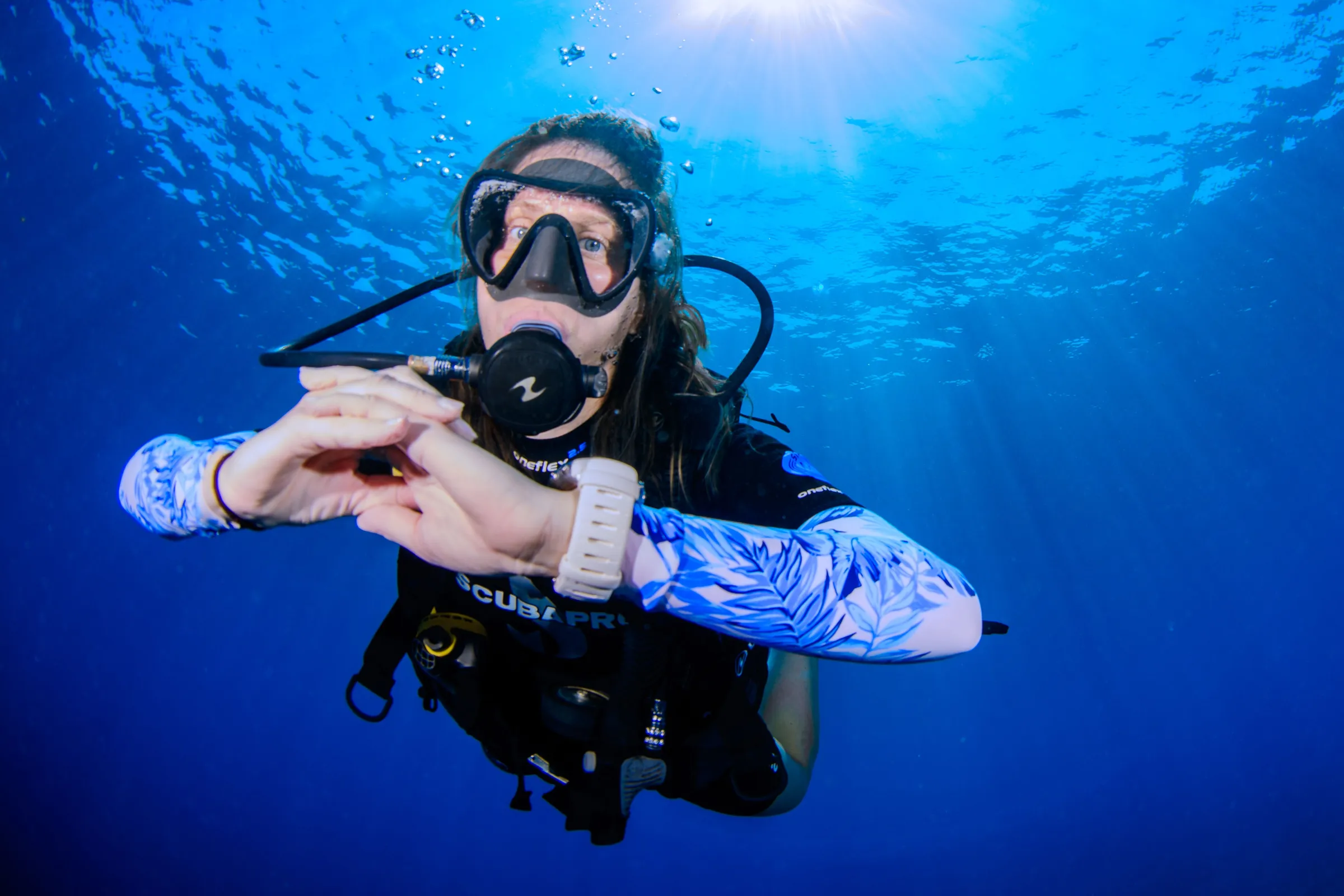 Diver giving heart sign in blue