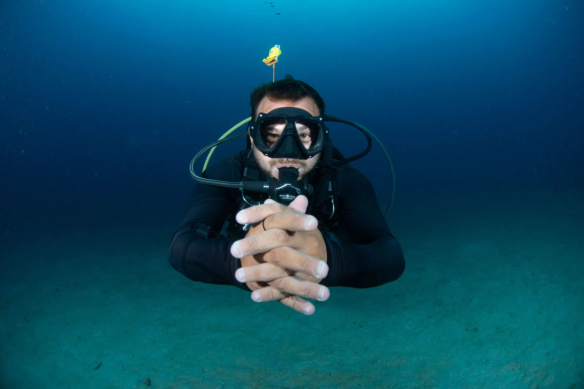 Diver crossing fingers in the blue